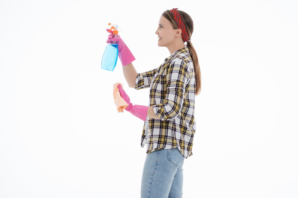 Image of a woman facing left dressed as a cleaner and holding a bottle of cleaning solution and a cloth
